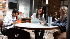 Three Students Sit Around Round Table Working Laptops 1281